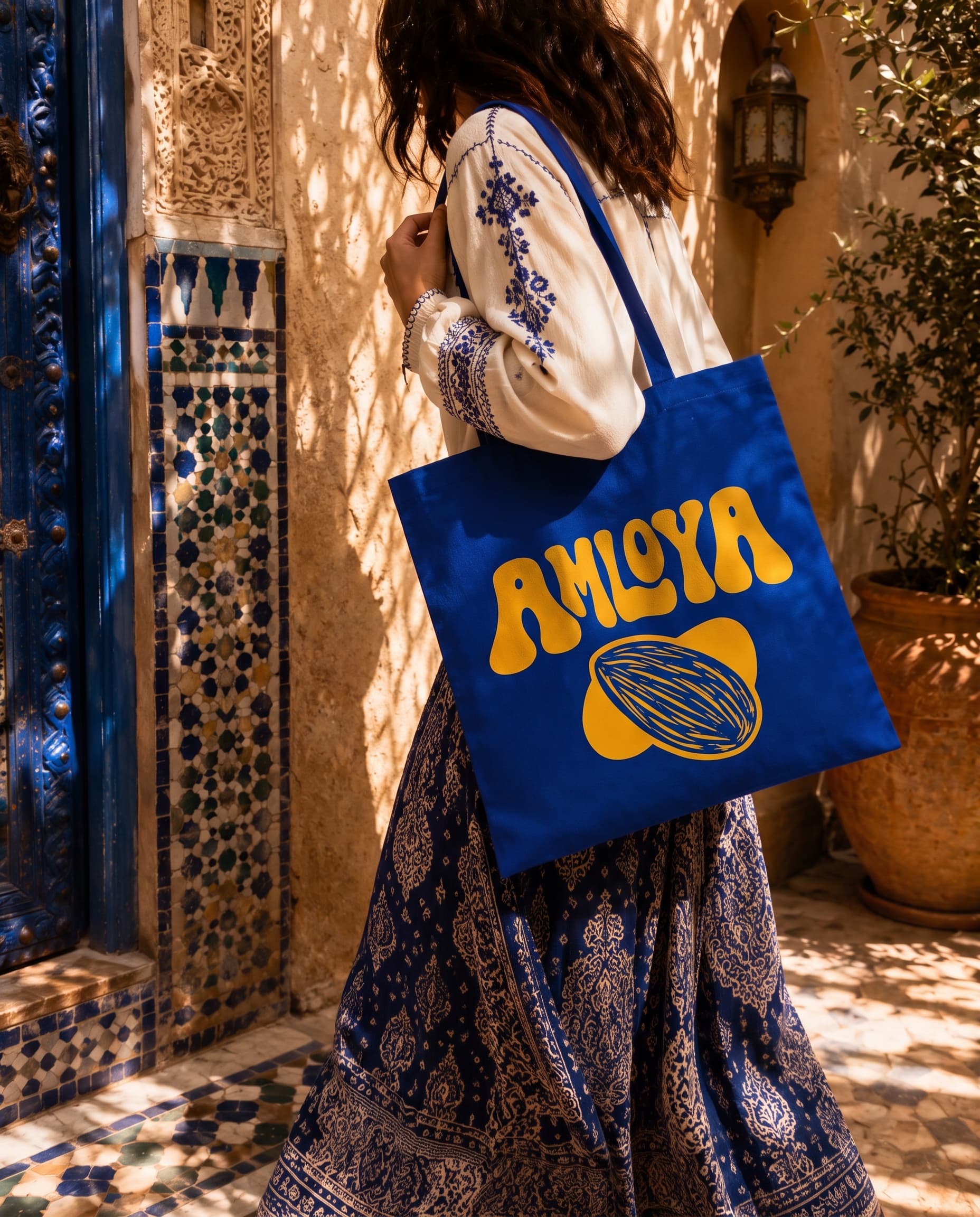 Tote bag AMLOYA bleu majorelle porté dans une ruelle marocaine